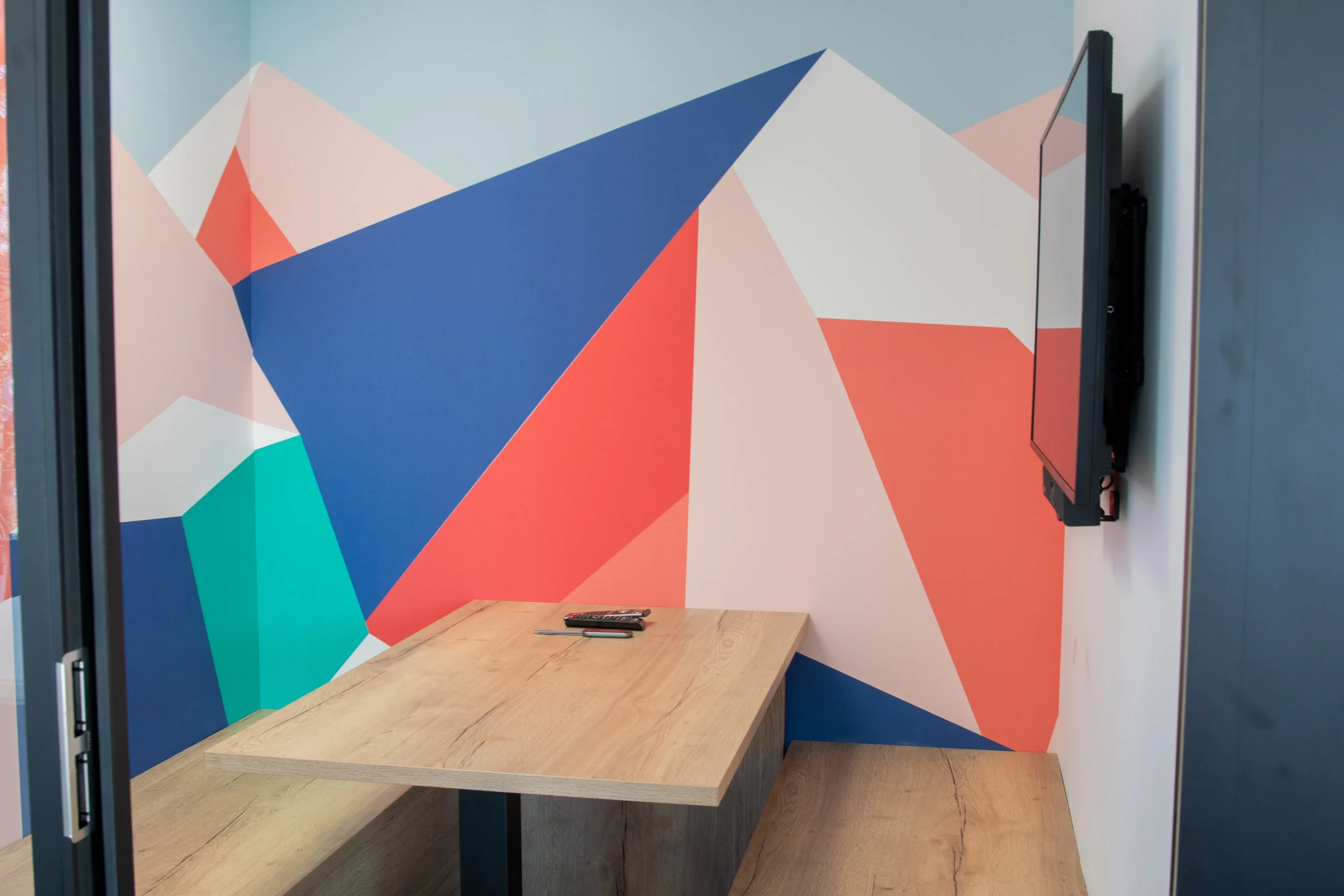 Coin visio avec écran et fresque murale géométrique