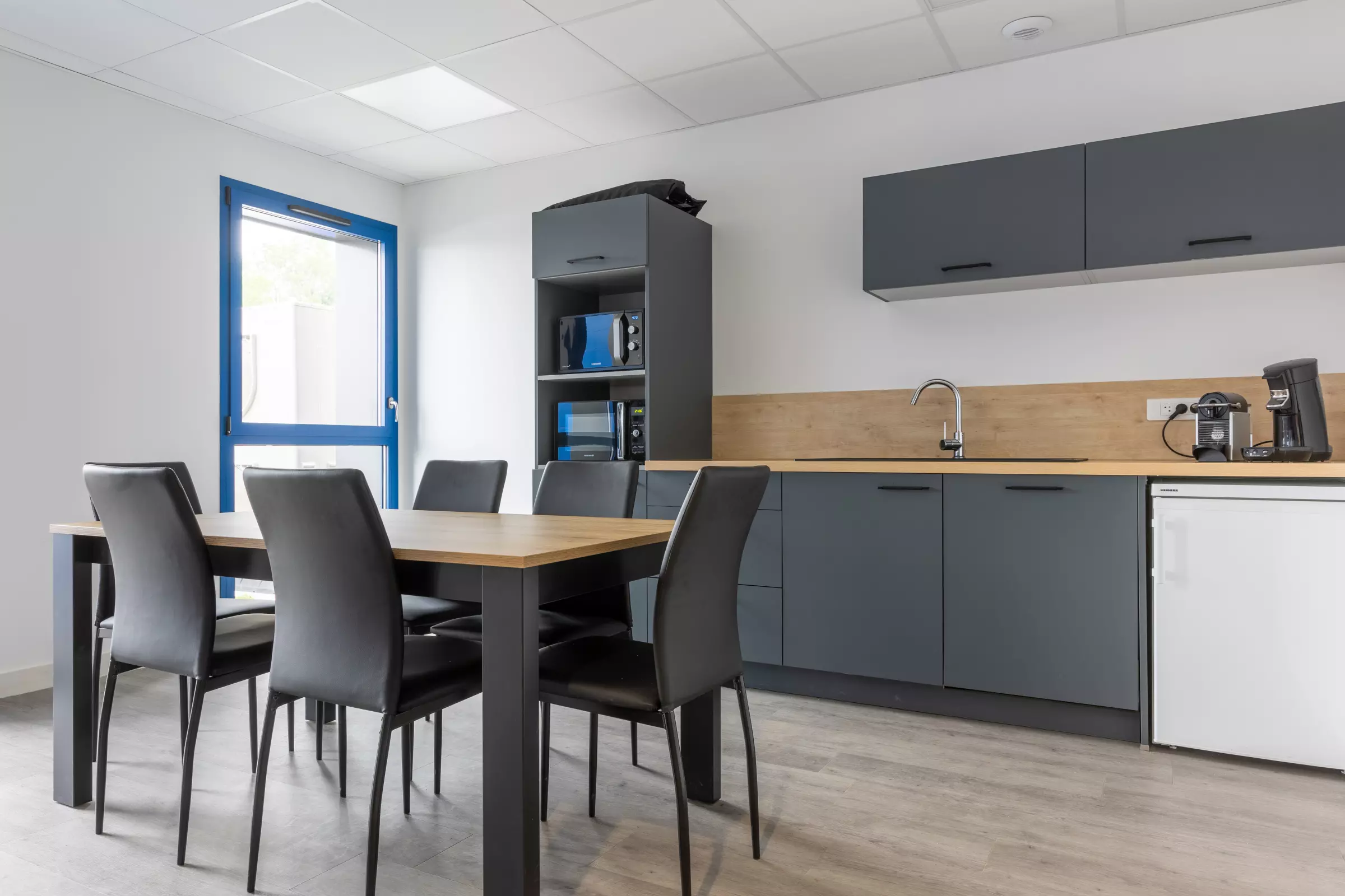 Salle de pause avec cuisine et niches pour micro ondes avec table repas